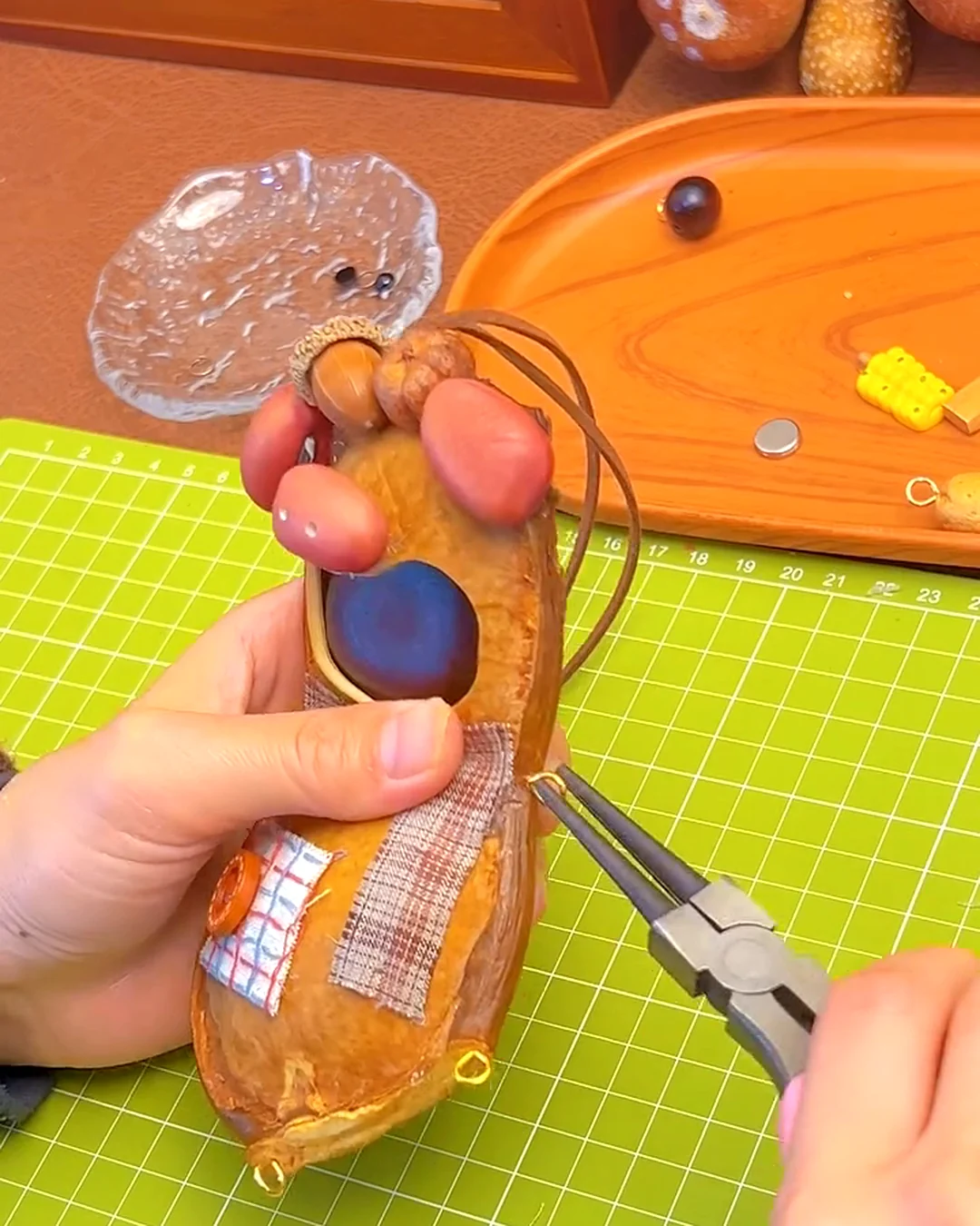 Side details and hanging parts being adjusted on a handmade pod doll.