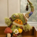 Small handmade collectible displayed on a wooden shelf