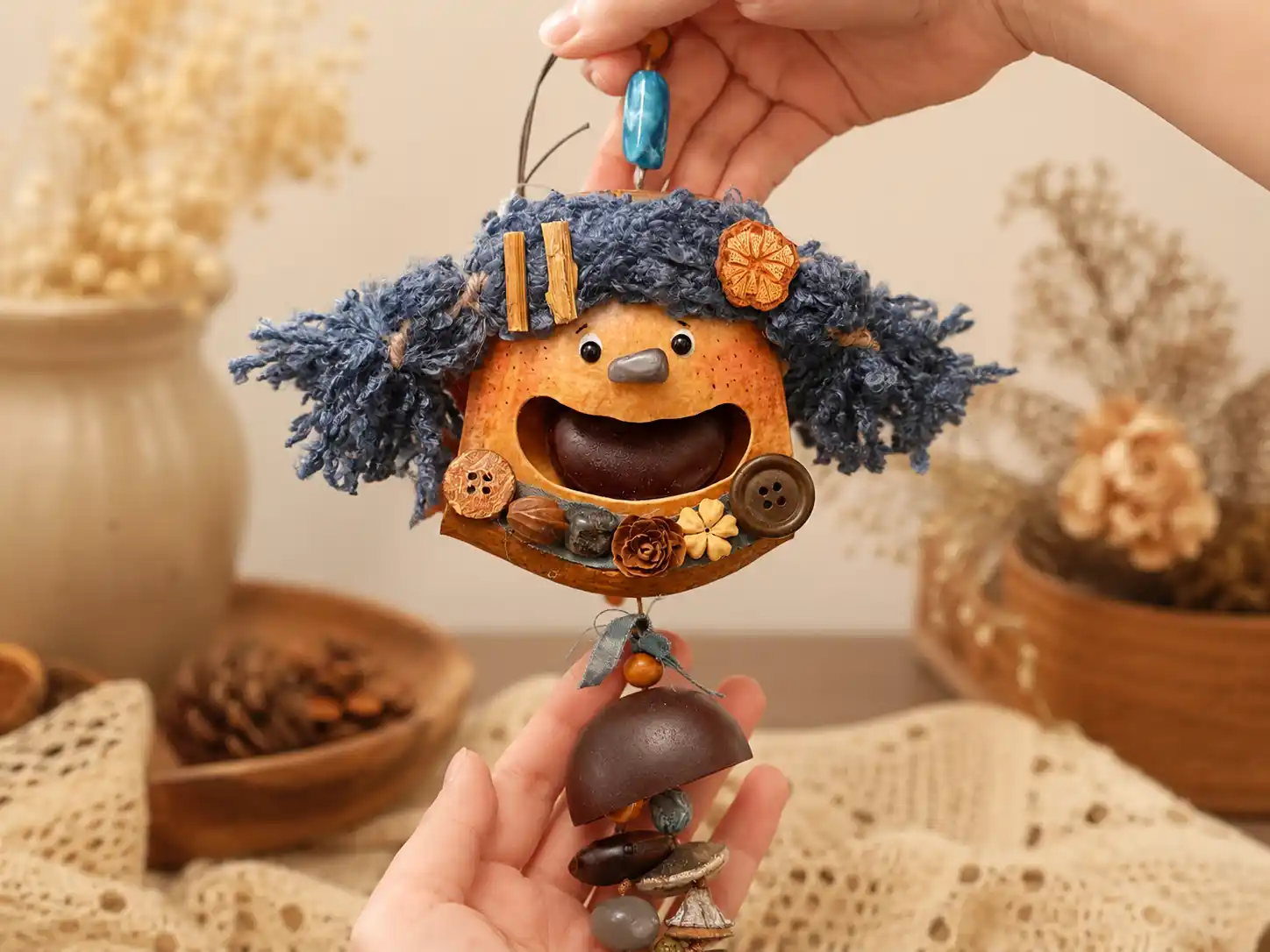 Handmade hanging Poddoll with blue curly hair, floral details, and an open-mouth face