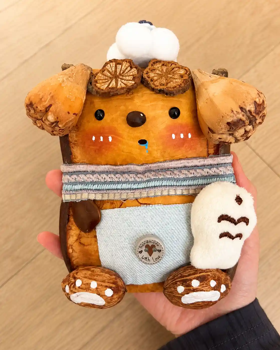 Handmade dog-like Poddoll wearing a blue apron and holding a soft yellow star