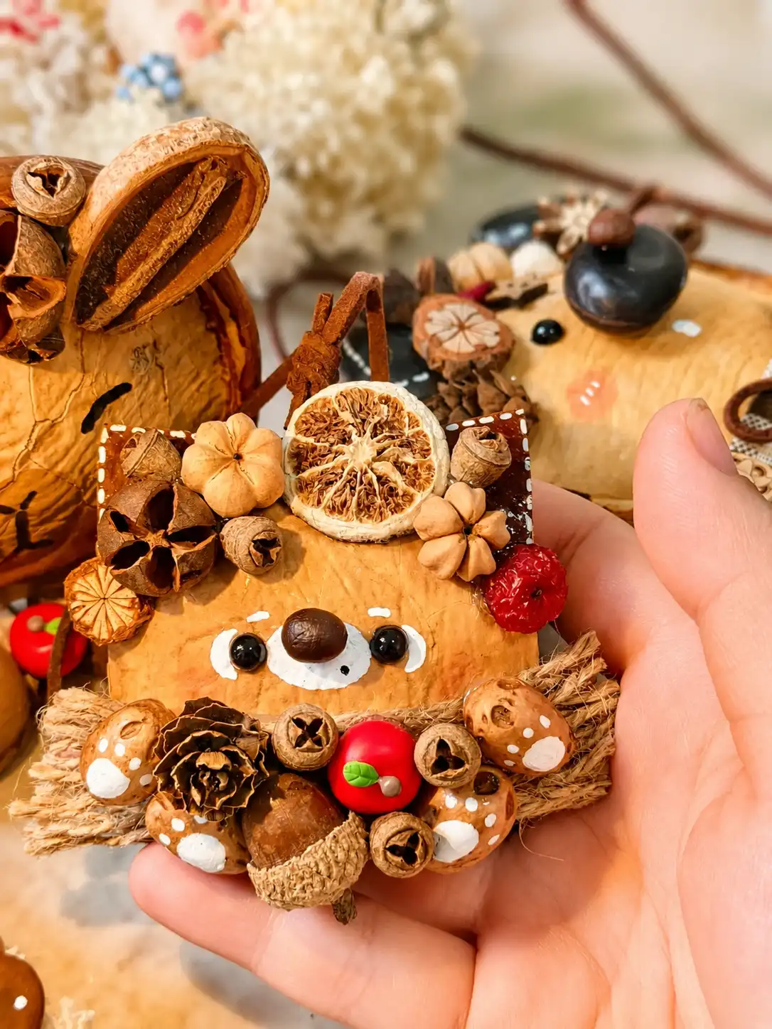 Handmade Poddoll decorated with dried botanical pieces, seed pods, an acorn, and a small red apple detail