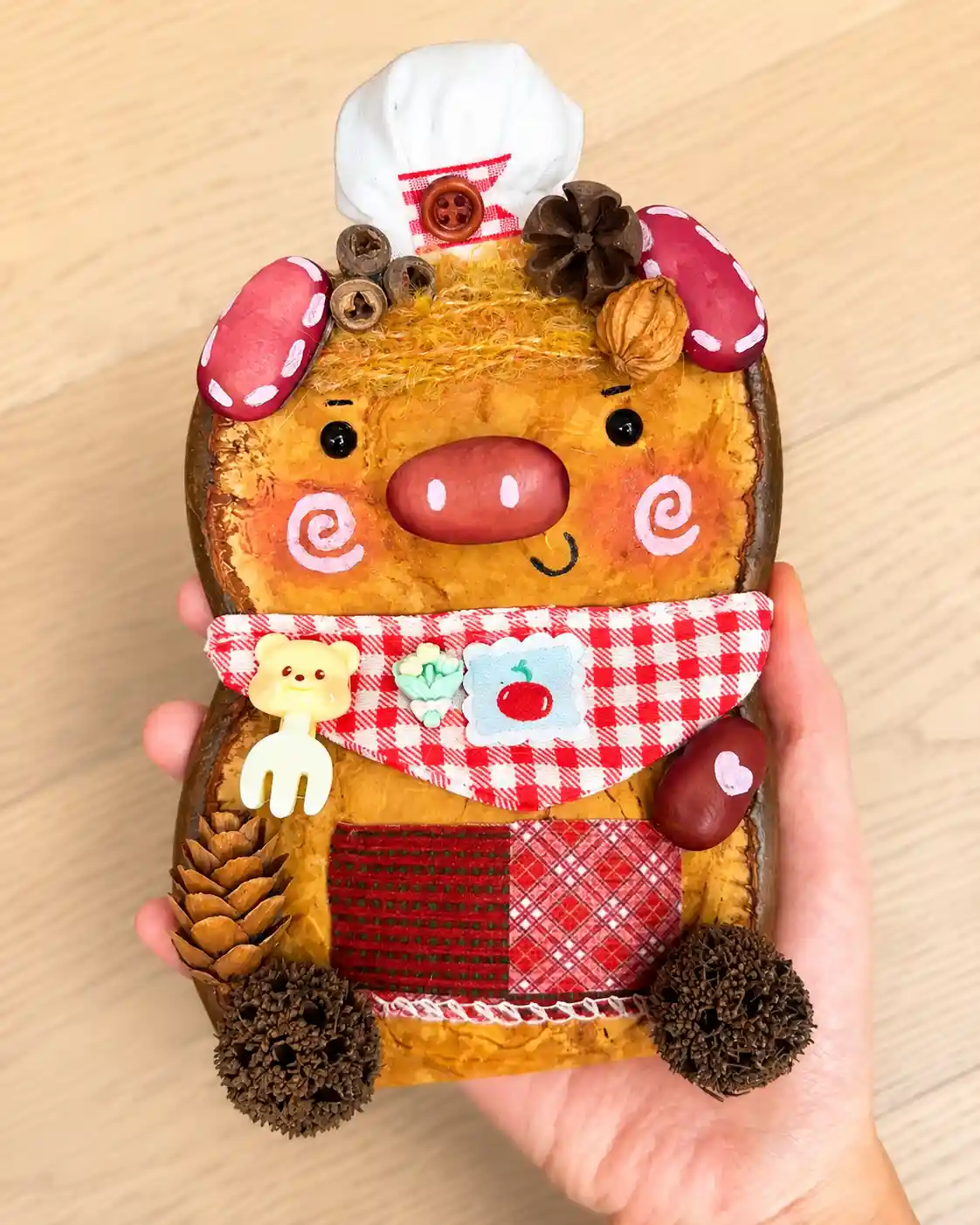 Handmade chef pig Poddoll with pink ears, a large snout, white chef hat, and red plaid apron