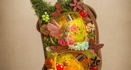 Full front view of a double-sided Poddoll with a moss-covered handle and glowing miniature forest scene
