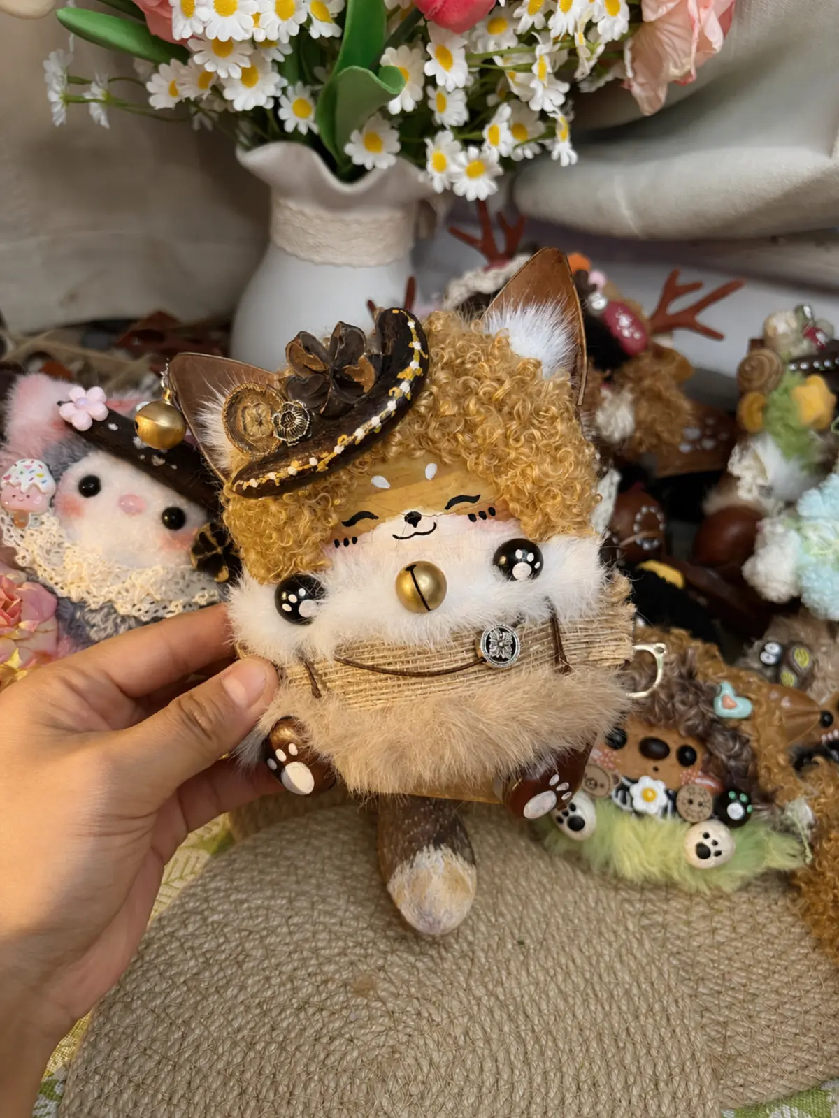 Handmade cat Poddoll held in front of a small collection of character dolls