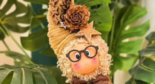 Small handmade Poddoll displayed among green plant leaves as a personal gift alternative