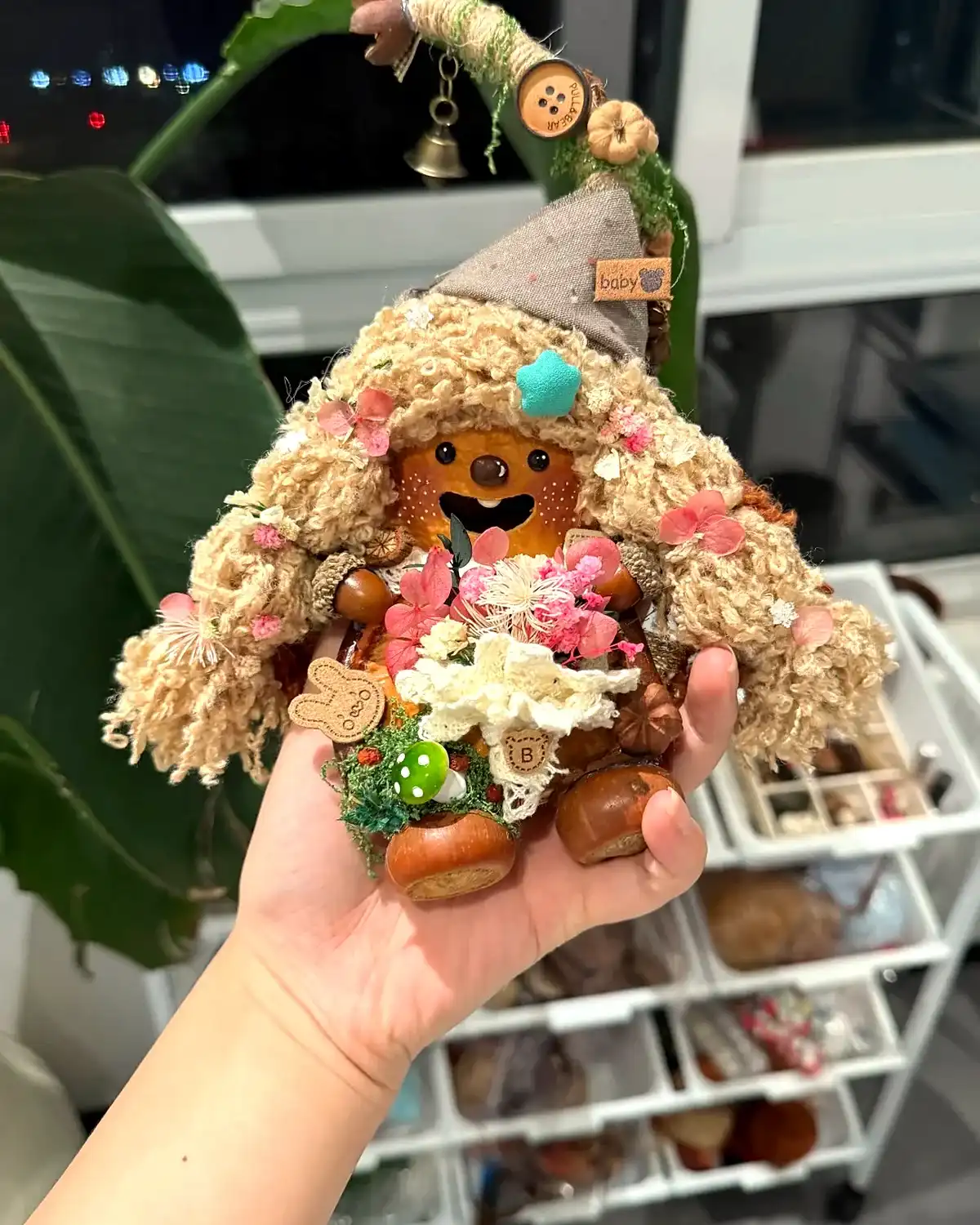 Small handmade Poddoll gift held in one hand with natural details